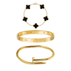 Set of gold bracelets with black clover and diamond designs on a white background