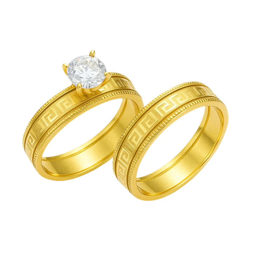 Two gold rings with intricate designs on a white background